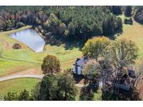 An aerial view of a charming home and acreage with a pond at 206 Pike Memory Ln, Staley, NC 27355