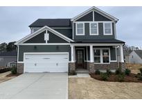 Charming two-story home features an attached two-car garage and stone accents at 409 Marthas View Way, Wake Forest, NC 27587