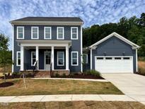 Beautiful two-story home features a welcoming front porch and attached two-car garage at 6044 Scalybark Road, Durham, NC 27712