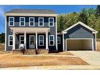 Charming two-story home boasts a welcoming front porch and attached two-car garage at 6044 Scalybark Road, Durham, NC 27712