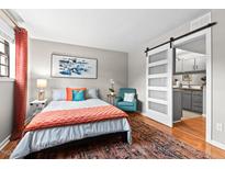 Bright bedroom with colorful accents, including an orange quilt and a teal chair at 807 W Trinity Ave # 220, Durham, NC 27701