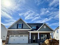 Charming new construction home featuring a brick facade, attached two-car garage, and well-manicured lawn at 1060 Fairhaven Dr # 96, Mebane, NC 27302