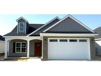 Charming new home with a two-car garage, brick accents, and a welcoming covered front porch at 180 Brunswick Dr, Nashville, NC 27856
