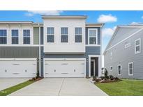 Charming townhome with a one car garage, blue siding, and well-manicured front yard at 20 Nettle Ln # 239, Clayton, NC 27520