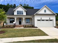 Charming new construction home with a two-car garage, landscaped front yard, and inviting front porch at 6040 Scalybark Road, Durham, NC 27712