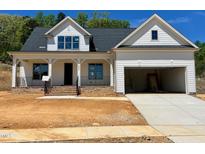 Beautiful new construction home with white siding, brick accents and an attached two car garage at 6040 Scalybark Road, Durham, NC 27712