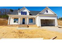 Beautiful white home featuring a brick base, two-car garage, and covered porch at 6040 Scalybark Road, Durham, NC 27712