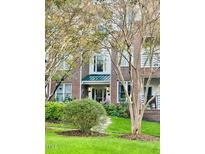Charming brick townhome with landscaped front yard and walkway surrounded by lush greenery and mature crepe myrtle trees at 710 N Person St # 304, Raleigh, NC 27604