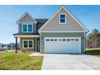 Charming two-story home with a two-car garage, craftsman touches, and a well-manicured lawn at 115 Tupelo Dr, Spring Hope, NC 27882