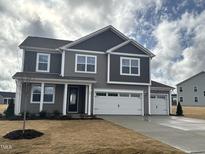 Beautiful two-story home featuring gray siding and a three-car garage at 88 Bering Cir, Angier, NC 27501