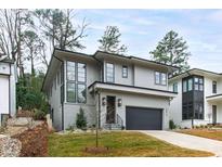 Contemporary two-story home with large windows, painted brick, and a well-manicured lawn at 2417 Mayview Rd, Raleigh, NC 27607
