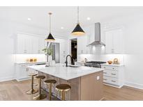 Bright, modern kitchen featuring white cabinets, stainless appliances, and an island with bar seating at 2417 Mayview Rd, Raleigh, NC 27607