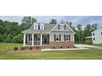 Charming single-Gathering home with tan siding, brick foundation, and a cozy front porch at 294 White Azalea Way, Homesite 74, Benson, NC 27504