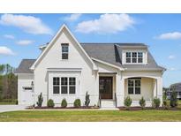 Charming white brick home featuring a dark wood front door, well-manicured lawn, and attractive landscaping at 3804 Cobbler View Way, Fuquay Varina, NC 27526