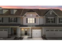 Two-story townhome with gray siding, stone accents, and a two-car garage at 813 Pryor St, Mebane, NC 27302