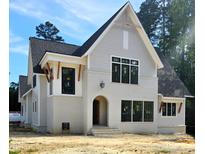 New two-story home features a mix of painted brick and gray siding, set against a backdrop of lush trees and blue skies at 3341 Colby Chase Dr, Apex, NC 27539