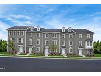 Three-story townhouses with gray siding, white trim, and a spacious front yard at 2103 Pitchfork Ln, Durham, NC 27713