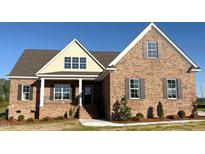 Beautiful brick home with shuttered windows, covered porch and charming architectural details under a bright blue sky at 7553 Sweetwater Dr, Nashville, NC 27856