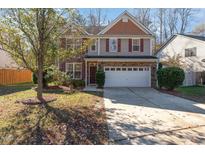 Charming two-story home featuring a stone facade, two-car garage, and a well-manicured lawn at 552 Stobhill Ln, Holly Springs, NC 27540