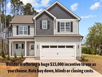 Charming two-story home featuring a modern exterior, a two-car garage, and well-maintained landscaping at 60 Bennett Rd, Coats, NC 27521