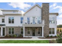 Modern farmhouse-style home with brick and white siding, balcony, and landscaping at 11549 Helmond Way # 114, Raleigh, NC 27617
