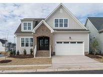 Charming home featuring a brick entryway, a two-car garage, and a well-manicured front yard at 201 Wash Hollow Dr, Wendell, NC 27591