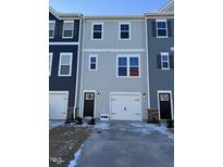 Two-story townhome with gray and blue siding, white garage door, and landscaping at 849 Parc Townes Dr # 11, Wendell, NC 27591