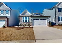 New construction home with stone and siding, two-car garage, and landscaped yard at 2430 Field Poppy Dr # 160, Apex, NC 27502