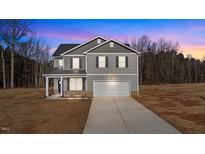Charming two-story home featuring a gray exterior, a two-car garage, and a long concrete driveway at 9184 Phoenix Ct, Spring Hope, NC 27882