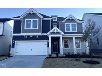 Two-story home with gray siding, stone accents, and a two-car garage at 1009 Bostonian Dr, Knightdale, NC 27545