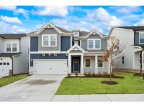Two-story home boasting a large front yard, an attached garage and beautiful blue and gray siding at 1009 Bostonian Dr, Knightdale, NC 27545