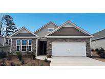 Charming home with stone accents, neutral siding, a two-car garage, and professionally landscaped yard at 1688 Abberly Pl, Graham, NC 27253