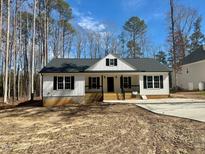 Charming new construction home featuring a classic white facade and welcoming front porch at 200 Rawhide Dr, Louisburg, NC 27549