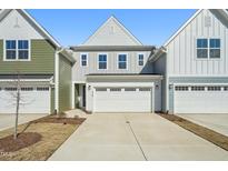Charming townhome with a two-car garage and inviting curb appeal on a bright, sunny day at 909 Montague Ave, Durham, NC 27703