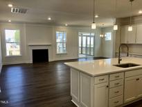 Bright living area features dark floors, fireplace, and screened-in porch access for seamless indoor-outdoor living at 1600 Maelyn Way, Fuquay Varina, NC 27526