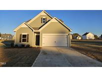 Two-story house with green siding, white garage door, and landscaping at 178 Vili Dr, Broadway, NC 27505