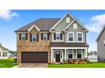 Charming two-story home featuring a brick and siding exterior, complemented by a well-manicured lawn and a two-car garage at 2750 Lacy Holt Rd, Graham, NC 27253