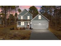 Two-story house with gray siding, a two-car garage, and a front porch at 35 Arbor Dr, Youngsville, NC 27596