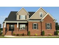 Beautiful brick home featuring a modern design, symmetrical windows and a well-maintained lawn at 7575 Sweetwater Dr, Nashville, NC 27856
