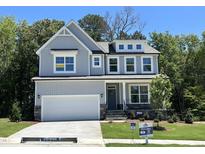 Beautiful two-story home featuring gray siding, stone accents, a two-car garage, and well-manicured front yard at 115 Arundel Dr, Archer Lodge, NC 27527