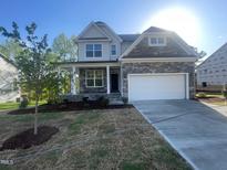 Beautiful two-story home featuring stone accents, a two-car garage, and a charming covered front porch at 116 Arundel Dr, Archer Lodge, NC 27527