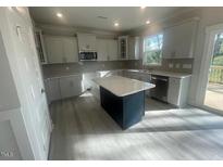 Bright kitchen features an island with a white countertop and stainless steel appliances at 116 Arundel Dr, Archer Lodge, NC 27527
