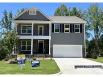 Two-story gray home with a two-car garage, stone accents, and a covered front porch at 118 Arundel Dr, Archer Lodge, NC 27527