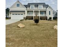 Inviting two-story home with a covered front porch and attached two-car garage, set on a spacious lot at 1233 Azalea Garden Cir, Raleigh, NC 27603
