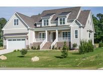 Charming two-story home with a covered porch, brick accents, and a well-manicured lawn at 1233 Azalea Garden Cir, Raleigh, NC 27603