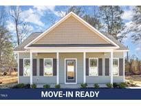 Charming single-story home with a welcoming front porch, well-maintained landscaping, and neutral color palette at 927 Micro W Rd, Selma, NC 27576