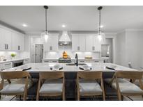 Modern kitchen island featuring a white marble countertop and seating, perfect for entertaining at 184 Dereham Ln, Garner, NC 27529