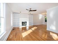 Bright living room features hardwood floors, fireplace, and built-in shelving at 3317 E Jameson Rd, Raleigh, NC 27604