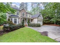 Charming two-story home boasts a stone and siding exterior, landscaped lawn, and an attached two-car garage at 1620 Dunn Rd, Raleigh, NC 27614