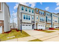 Charming townhome with stone accents, a two-car garage, and professionally landscaped front yard at 2729 Hunter Woods Dr # 568, Apex, NC 27502